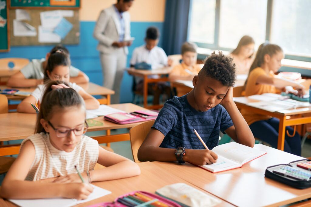 Alumnos de primaria escribiendo dictados durante la clase en el aula.